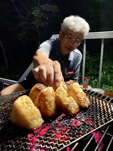 08_1_焼きおにぎりに手を伸ばす佳一さん